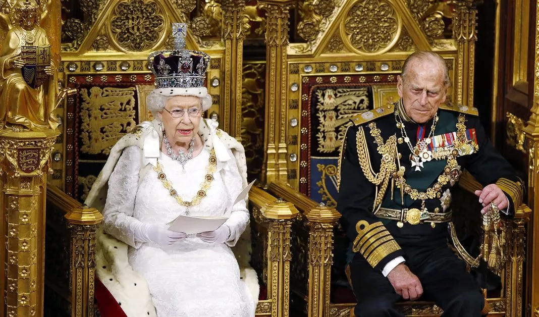 Королева Елизавета II читает речь королевы на своем троне, а принц Филипп, герцог Эдинбургский, слушает во время государственного открытия парламента