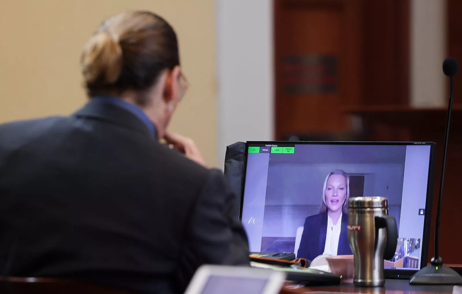 Джонни Депп слушает, как его бывшая девушка, модель Кейт Мосс дает показания по видеосвязи во время судебного процесса Деппа против его бывшей жены Эмбер Херд в окружном суде округа Фэрфакс, 25 мая 2022 г.