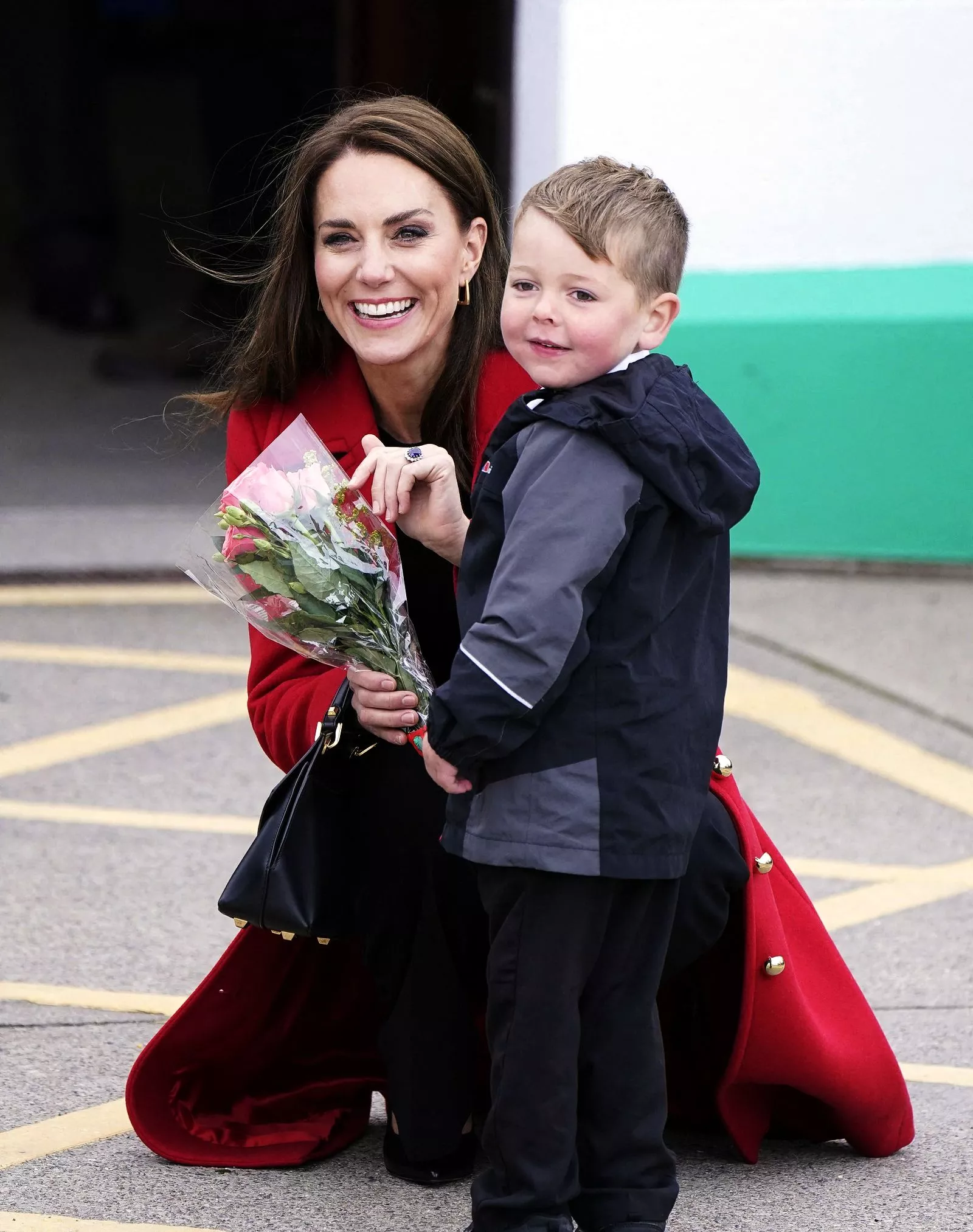 Кэтрин, принцесса Уэльская, получает букет цветов от четырехлетнего Тео Кромптона во время визита на спасательную станцию RNLI Holyhead в Холихеде, 27 сентября 2022 г.