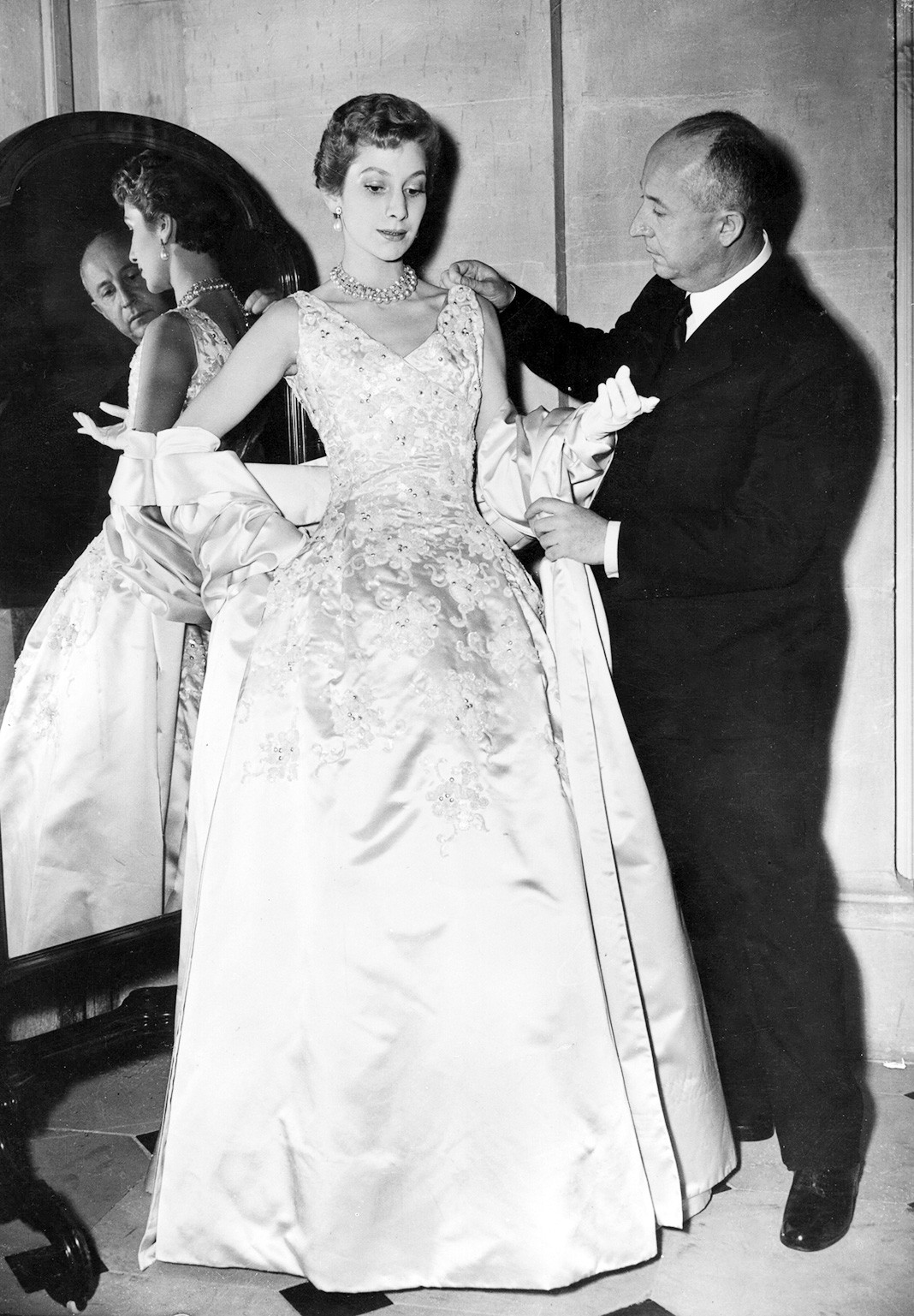 За работой над атласным вечерним платьем Blenheim, 1950 г.