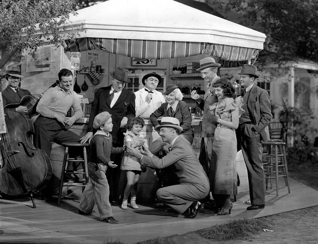 Уильям Пауэлл дарит мороженое Дики Джонсу и Джини Ганн, двум детям-актерам за их хорошие выступления. Также присутствуют Джин Харлоу, Тед Хили и Герман Бинг, примерно 1934 г.