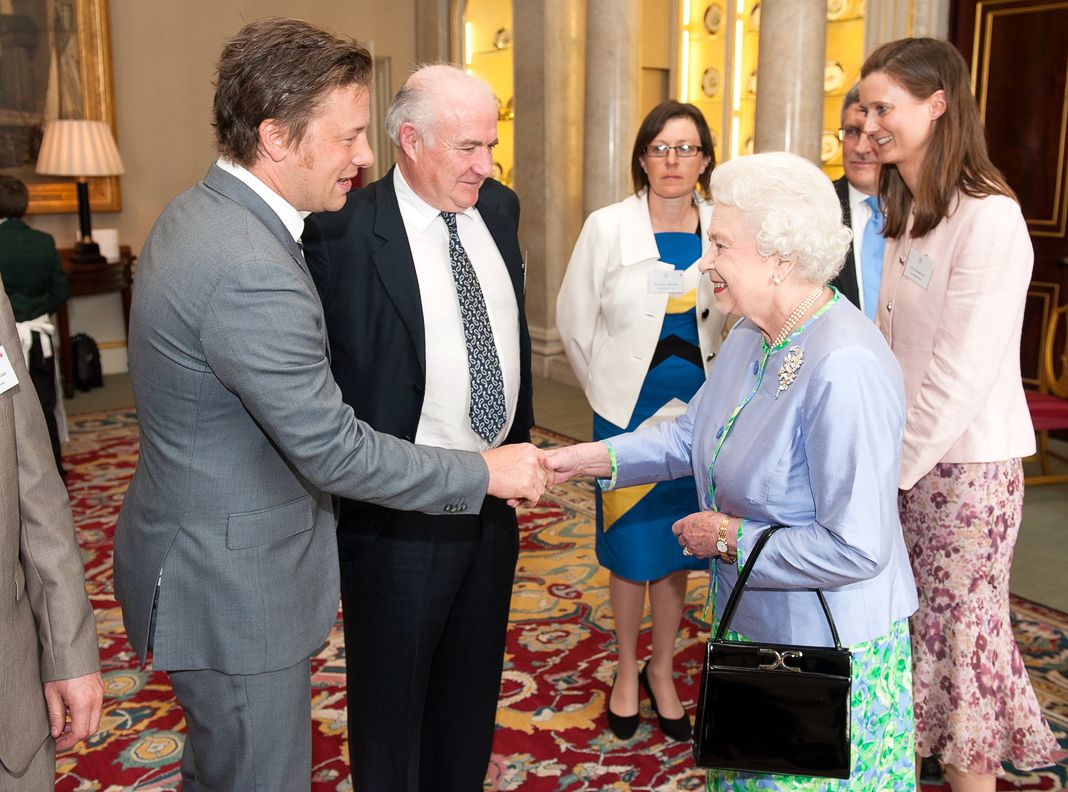 Королева Елизавета II встречается с шеф-поварами Джейми Оливером и Риком Стейном на приеме в Букингемском дворце