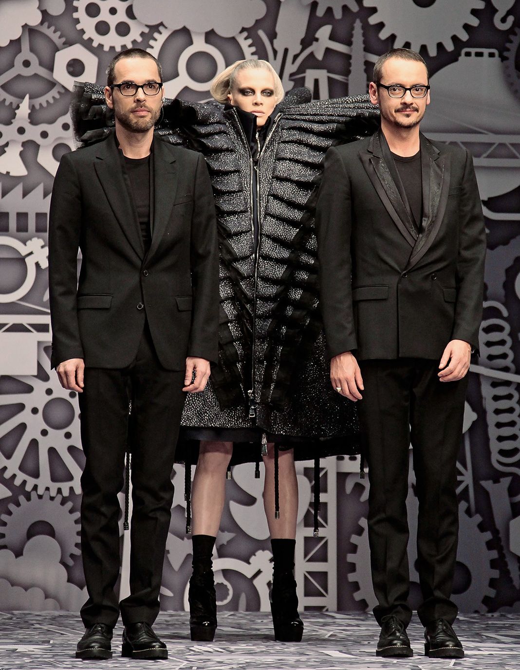 Дизайнеры Виктор и Рольф позируют с моделью Кристен МакМенами во время показа Viktor & Rolf Ready to Wear.