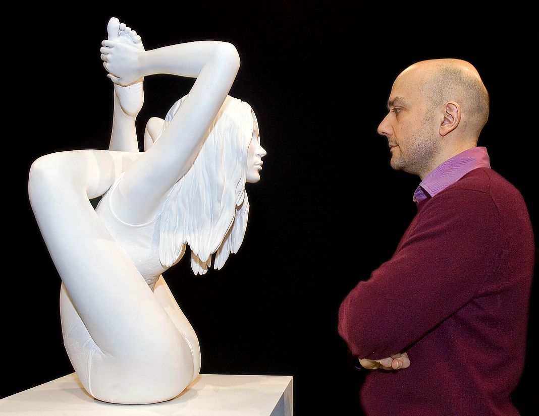 Художник Марк Куинн стоит со своим новым произведением под названием «Сфинкс», которое представляет собой скульптуру супермодели Кейт Мосс в позе йоги