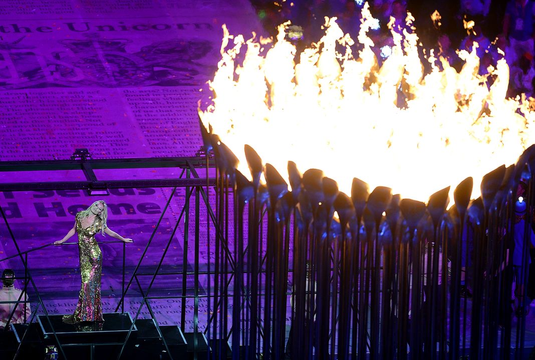 Модель выступает перед Олимпийским котлом во время церемонии закрытия 16-го дня Олимпийских игр 2012 года.