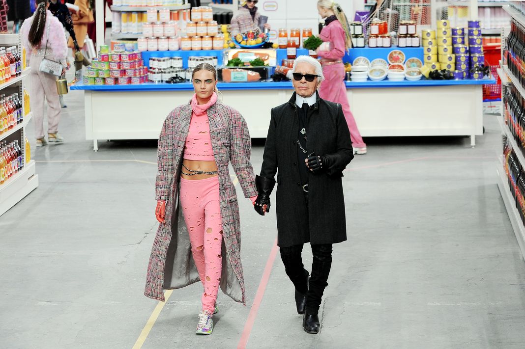Модельер Карл Лагерфельд и модель Кара Делевинь появляются в конце подиума во время показа Chanel.