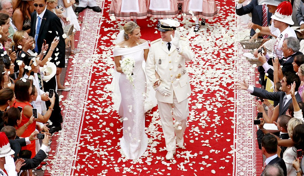 Принцесса Монако Шарлен и принц Монако Альбер улыбаются, покидая дворец после церемонии Королевской свадьбы
