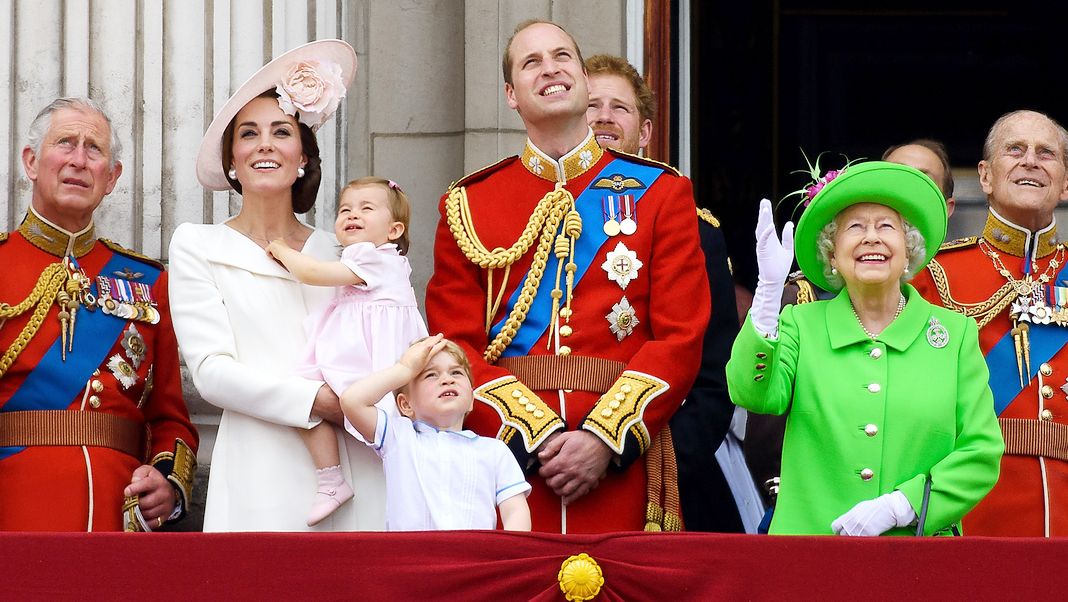Принц Чарльз, принц Уэльский, Кэтрин, герцогиня Кембриджская, принцесса Шарлотта, принц Джордж, принц Уильям, герцог Кембриджский, принц Гарри, королева Елизавета II и принц Филипп, герцог Эдинбургский, стоят на балконе
