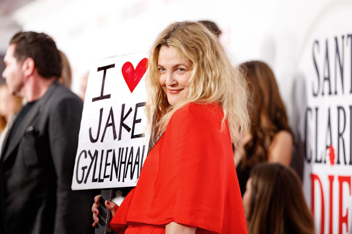 Дрю Бэрримор держит табличку с надписью «Я люблю Джейка Джилленхола» на премьере второго сезона сериала «Диета из Санта-Клариты» в Голливуде, 22 марта 2018 г.