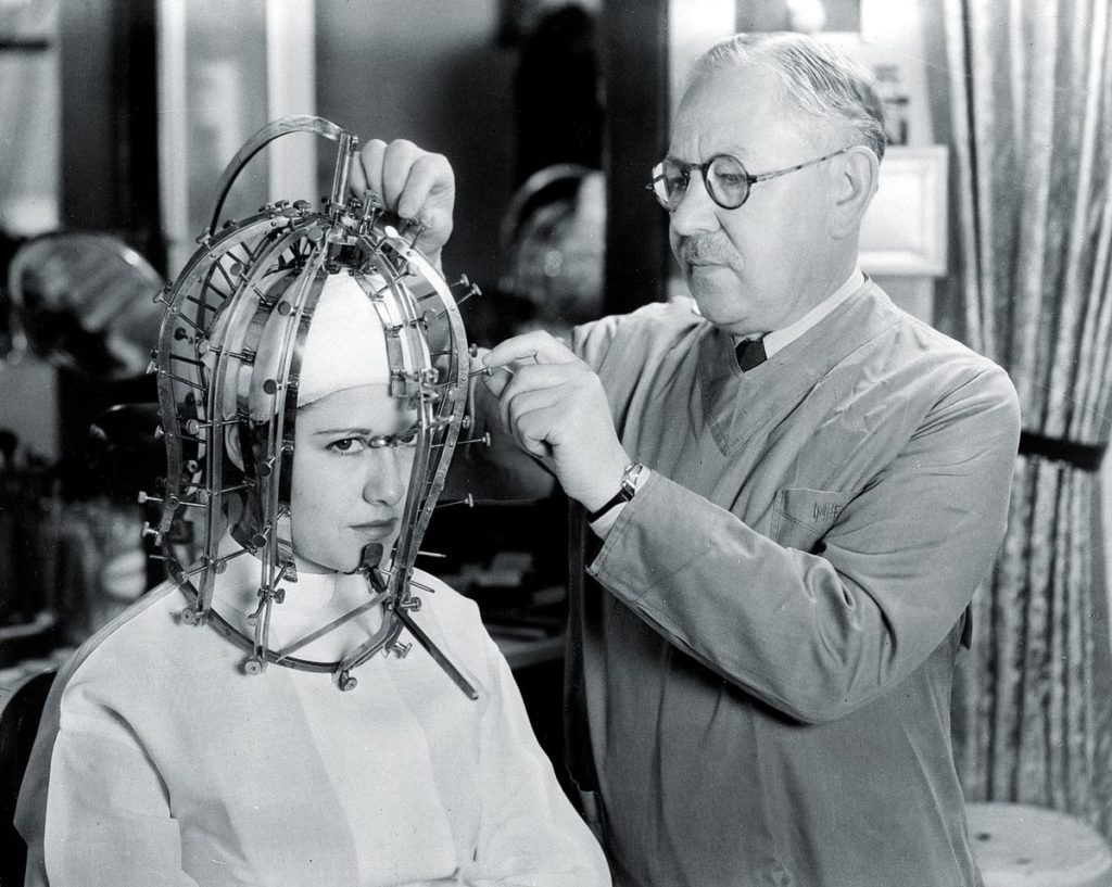 Голливудский косметолог Макс Фактор делает точные измерения головы и лица молодой женщины