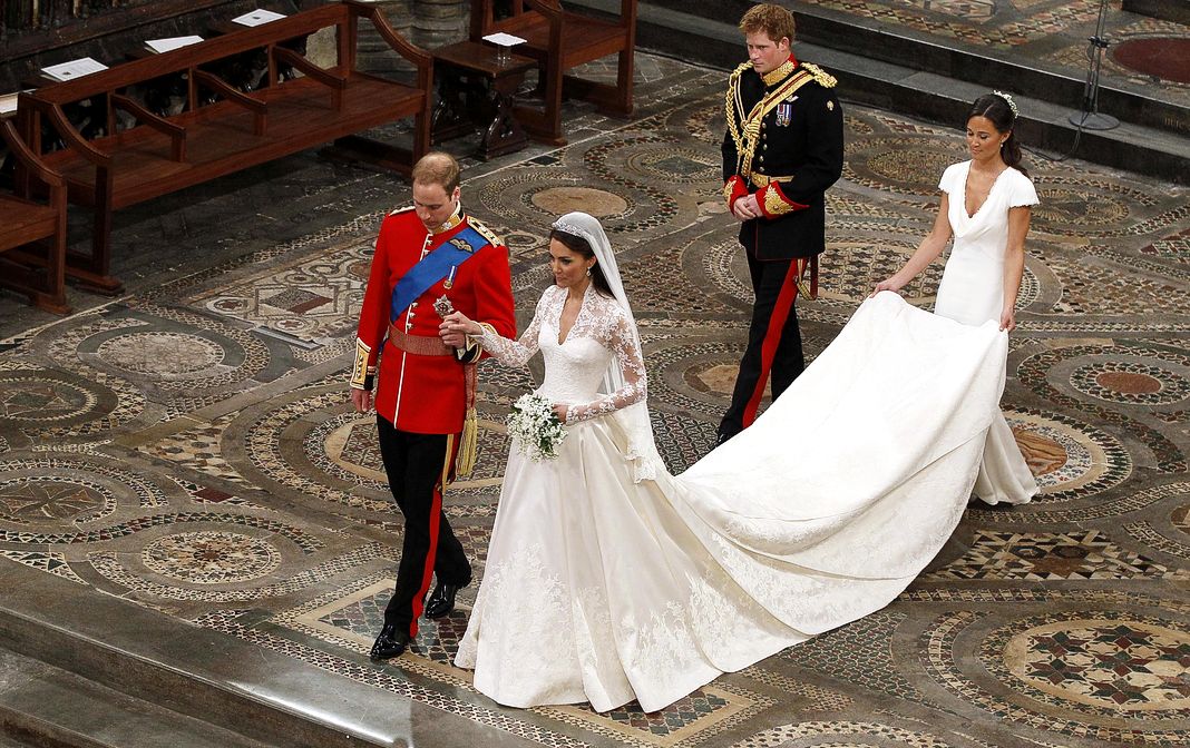 Принц Уильям ведет за руку свою невесту Кэтрин Миддлтон, за которой следуют принц Гарри и Пиппа Миддлтон