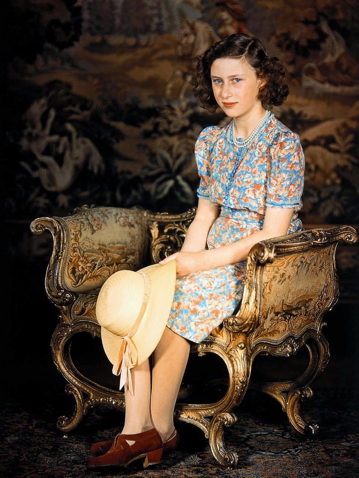 Принцесса Англии, сидящая в разноцветном платье и держащая соломенную шляпу, 1944 г.