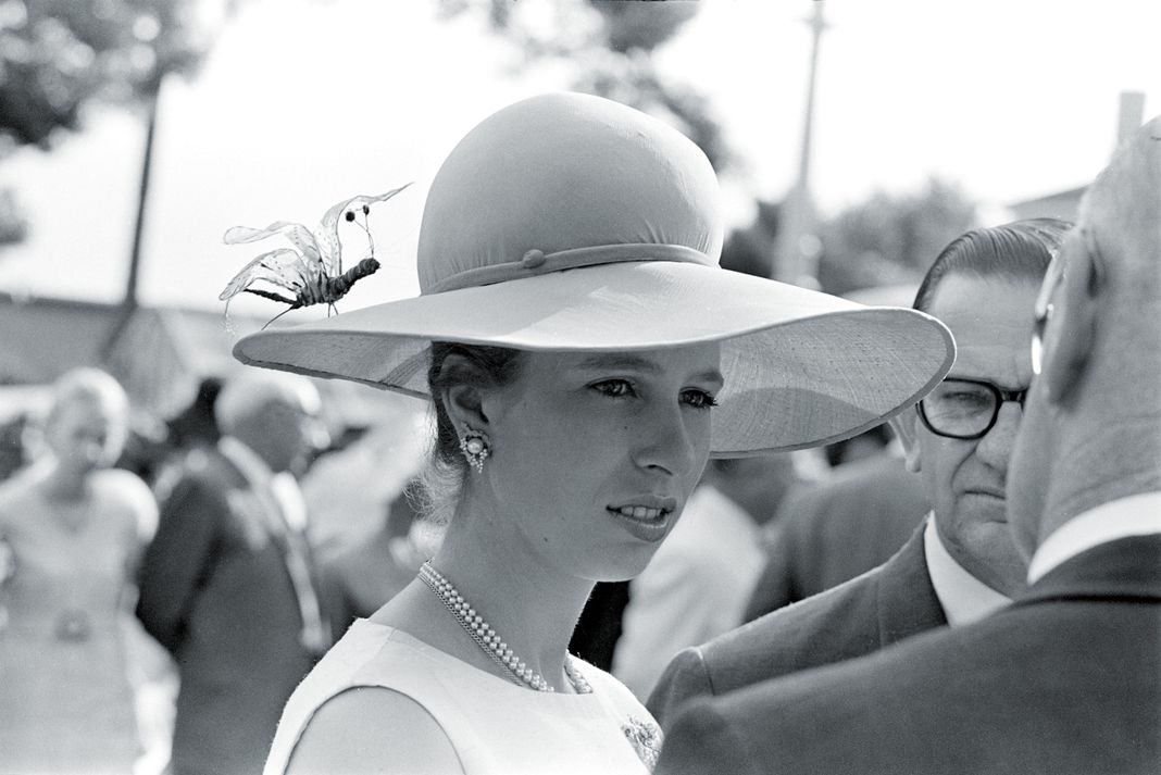 Принцесса Анна в широкополой шляпе с искусственным насекомым на показе мод
