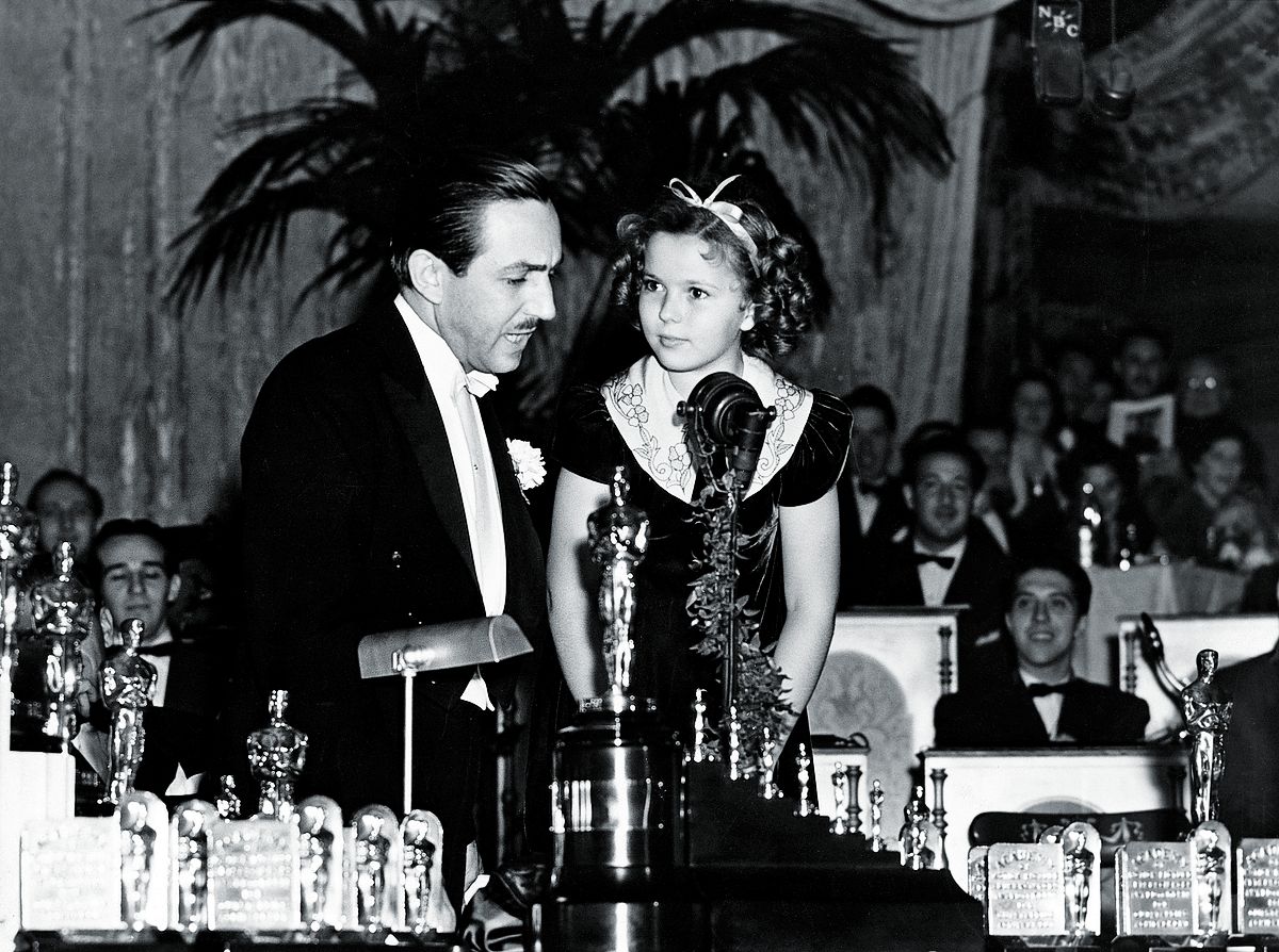 Детская звезда Ширли Темпл вручает Уолту Диснею «Оскар» и семь миниатюрных статуэток за его первый полнометражный мультфильм «Белоснежка и семь гномов», 1938 г.