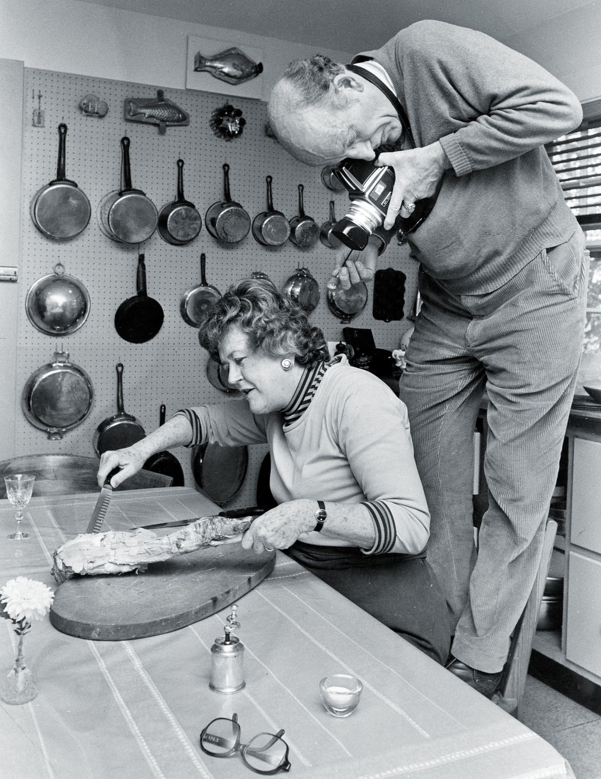 Джулия Чайлд режет баранину, пока ее муж, Пол Чайлд, фотографирует ее для книжной иллюстрации