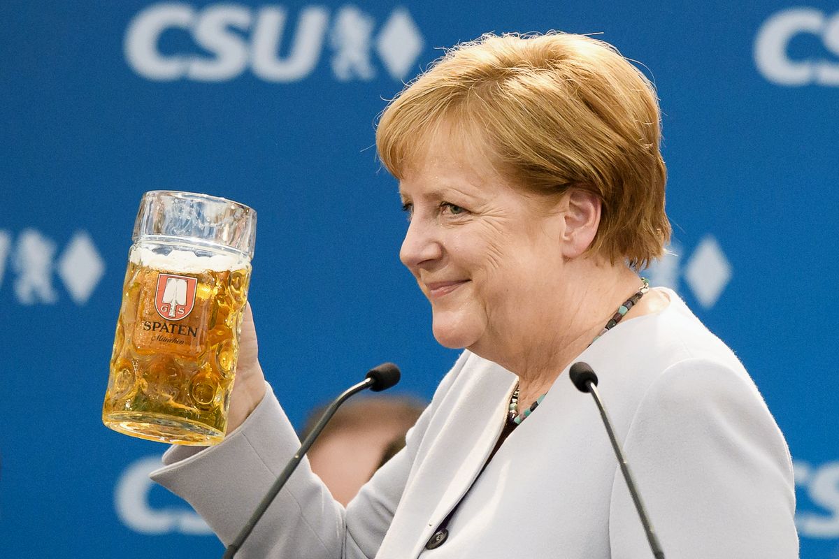 Канцлер Германии Ангела Меркель держит кружку пива после своего выступления