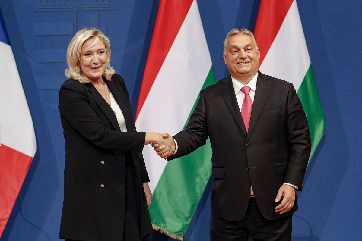 Пожимает руку премьер-министру Венгрии Виктору Орбану
