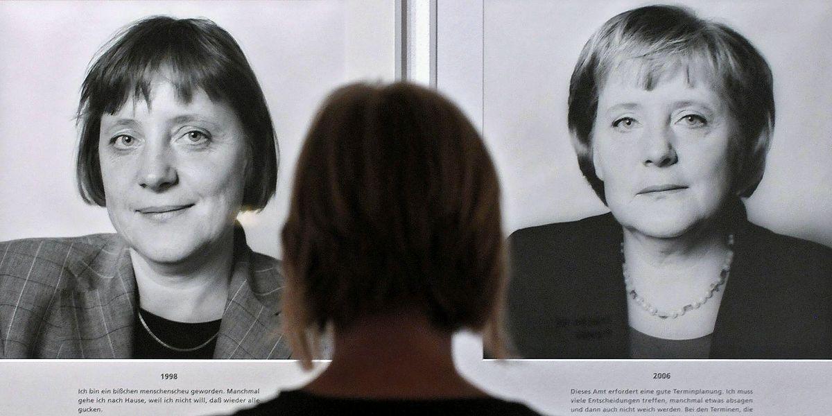 Посетитель рассматривает серию фотографий «Spuren der Macht» («Следы силы») с изображением канцлера Германии Ангелы Меркель