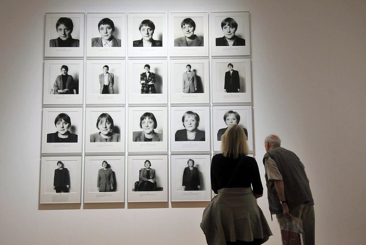 Посетители рассматривают серию фотографий под названием «Spuren der Macht» («Следы власти») с изображением канцлера Германии Ангелы Меркель