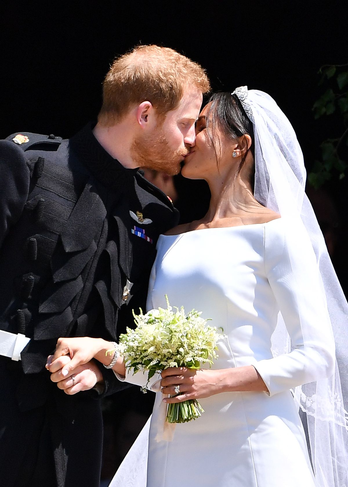 Принц Гарри целует свою жену Меган когда они выходят из часовни Святого Георгия