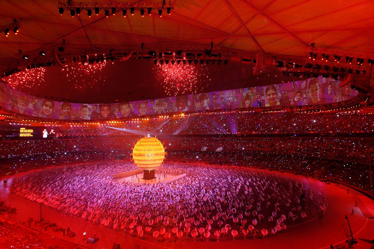 Сара Брайтман и Лю Хуан поют на вершине большого земного шара во время церемонии открытия летних Олимпийских игр