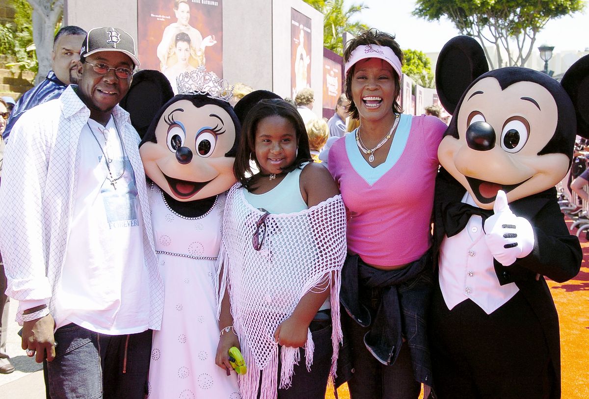 Уитни Хьюстон, Бобби Браун и их дочь Бобби Кристин приветствуют Микки Маус и Минни Маус на премьере фильма «Дневники принцессы»