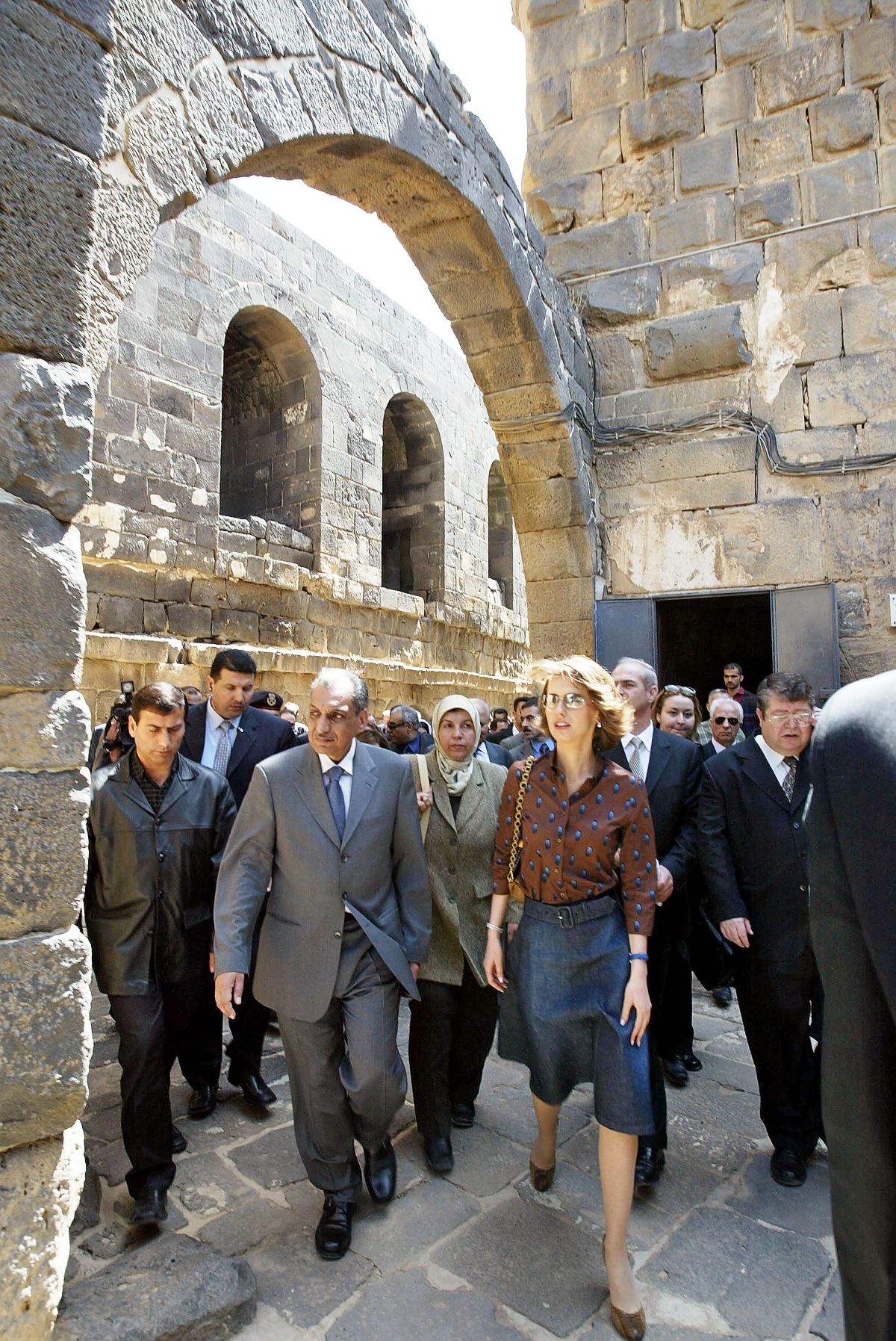 Асма Асад идет по замку у древних руин Босры