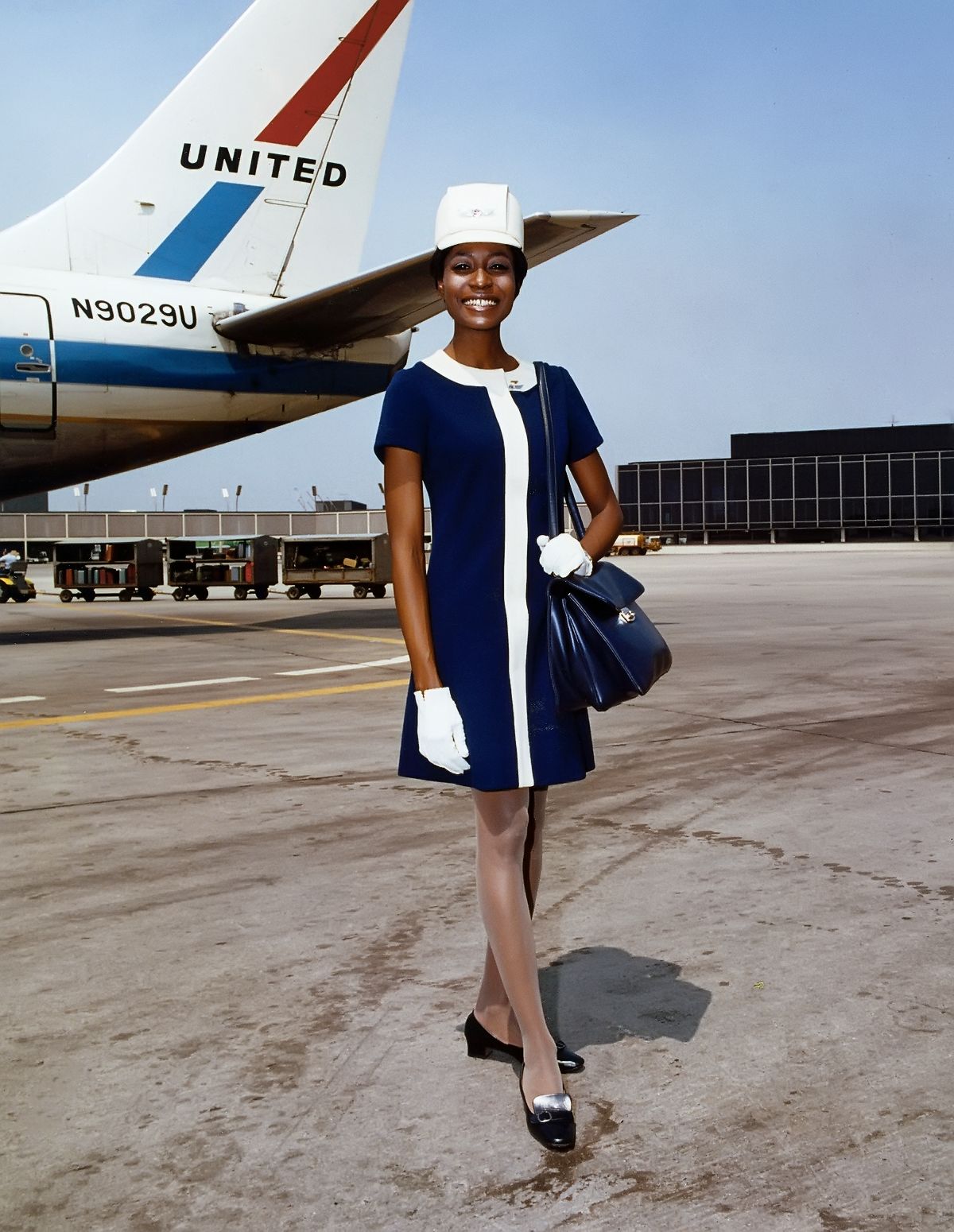 Стюардесса United Airlines в комплекте униформы разработанной Жаном Луи Берто
