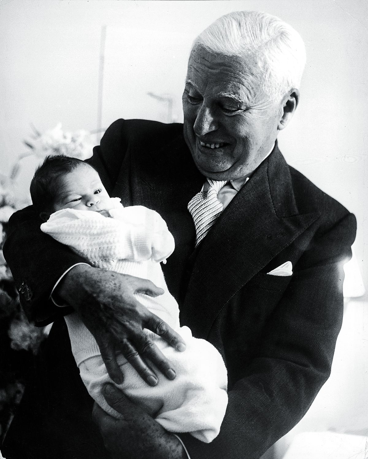 Чарли Чаплин держит своего недельного сына Кристофера