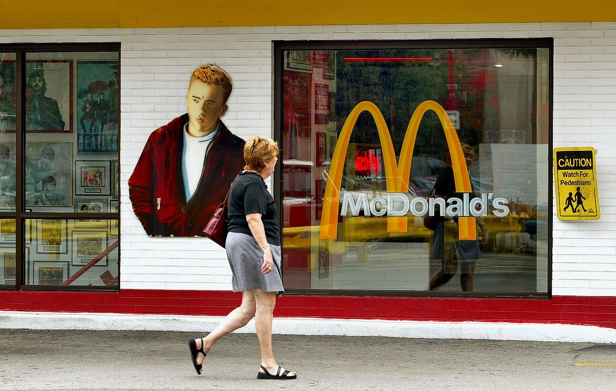 Покупатель проходит мимо настенного изображения Джеймса Дина в «Rock'N'Roll McDonald's»