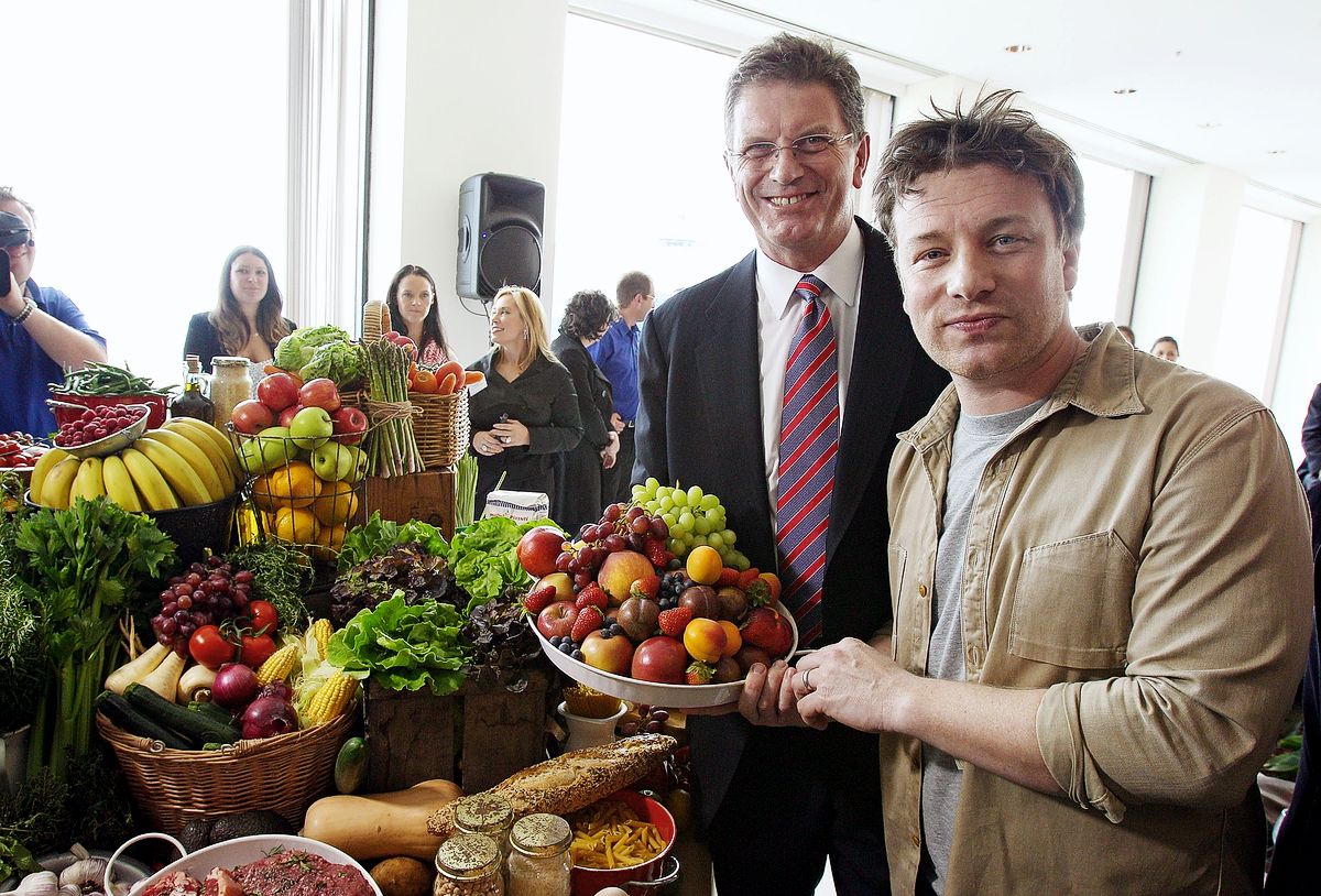 Шеф-повар Джейми Оливер держит тарелку свежих фруктов вместе с премьер-министром Виктории Тедом Байе