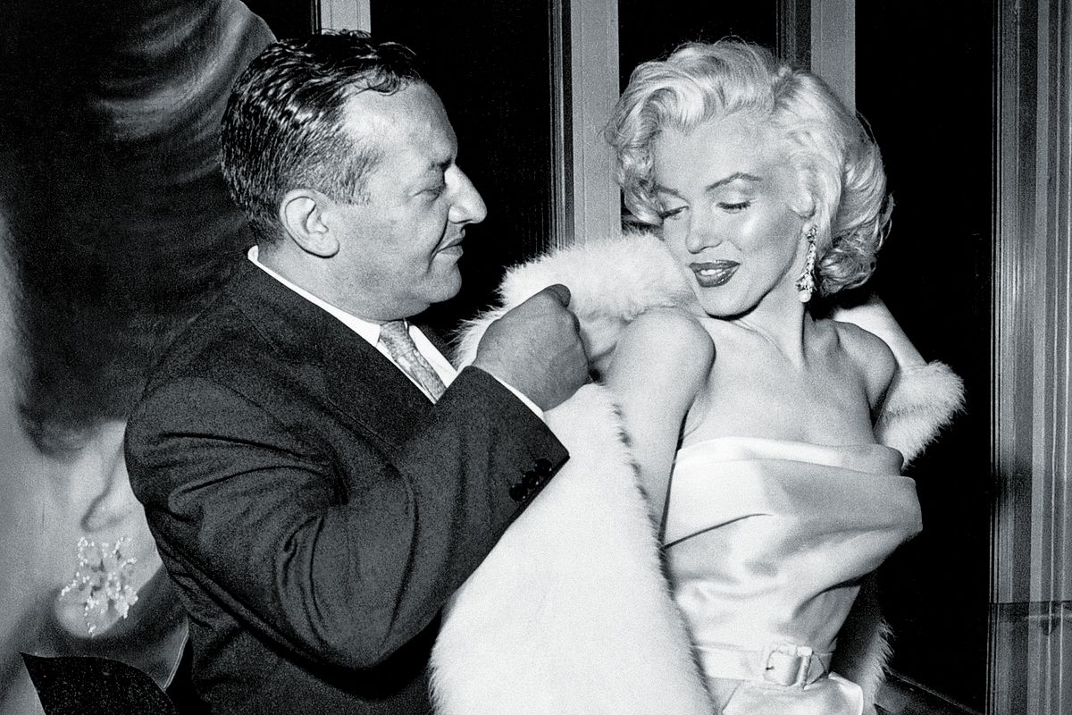 Герман Ховер помогает Мэрилин Монро надеть пальто, 1957 г.
