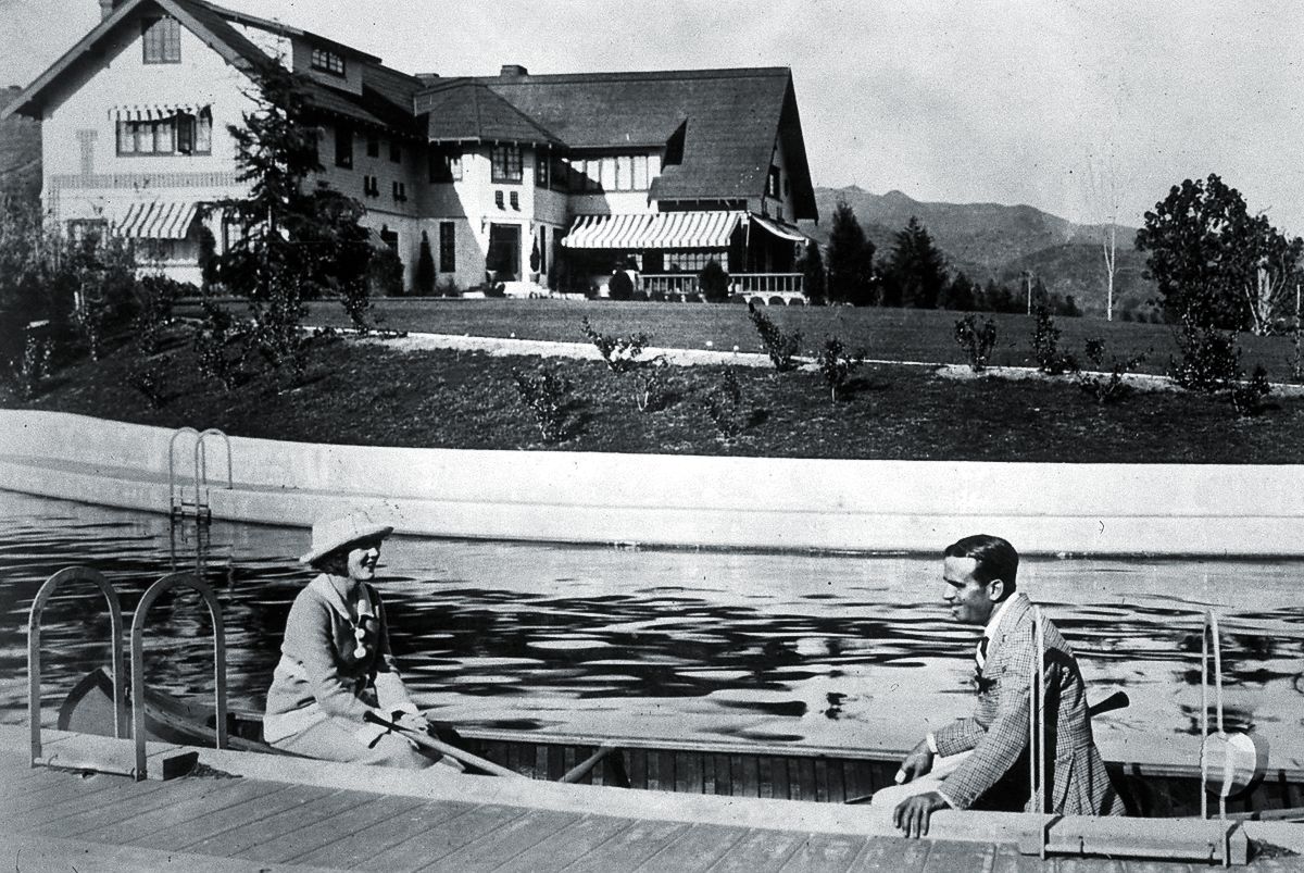 Мэри Пикфорд и Дуглас Фэрбенкс плывут на каноэ по ручью в своем поместье Пикфэр