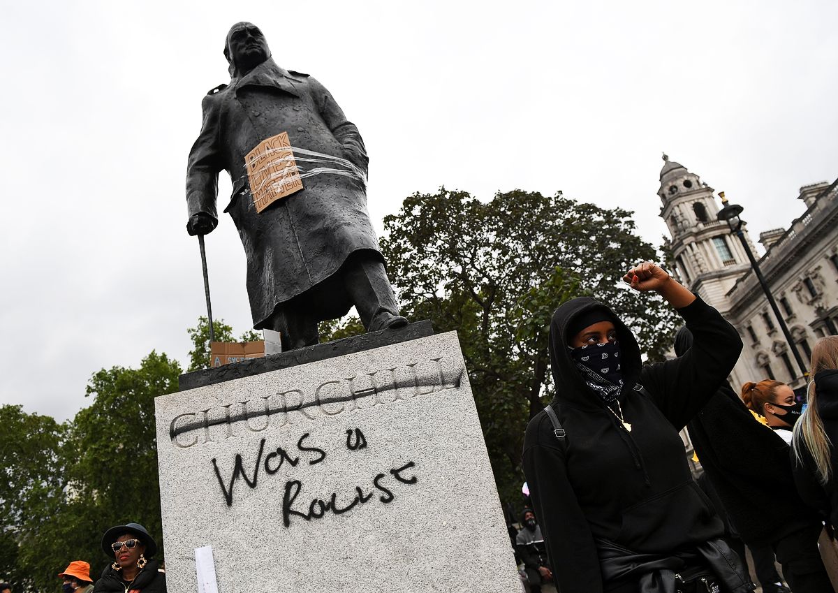 Протестующие собираются в Парламент-сквер-гарден вокруг статуи Уинстона Черчилля, на которой есть граффити со словами «был расистом»