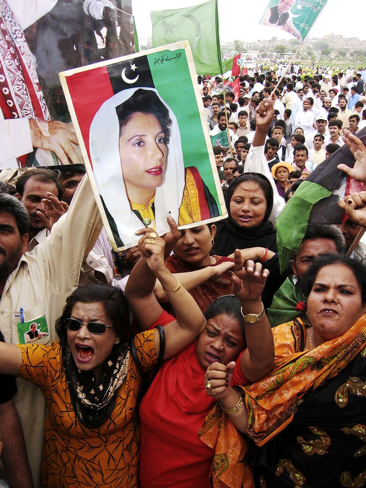 Работники Пакистанской народной партии держат фотографию Беназир Бхутто и выкрикивают лозунги в пользу экс-премьера Пакистана