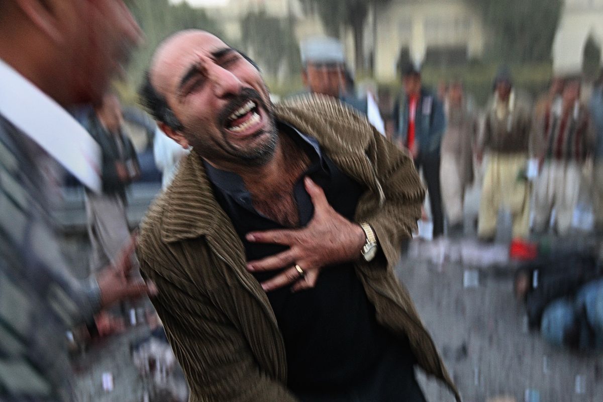 Выживший скорбит на месте покушения на бывшего премьер-министра Беназир Бхутто после предвыборного митинга